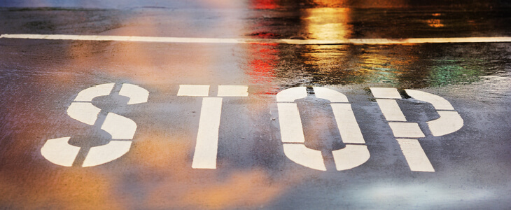 STOP printed on a wet road surface