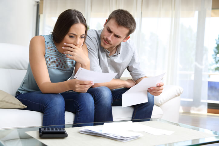 Man and woman looking at traffic ticket at home