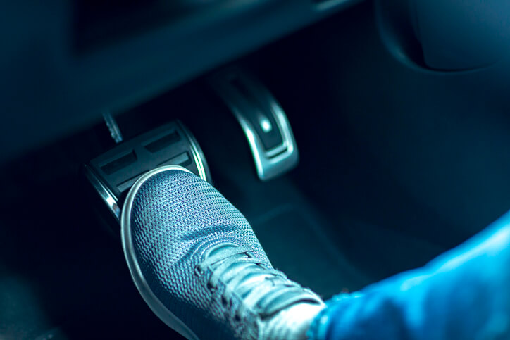Man pressing on the brake pedal in his car