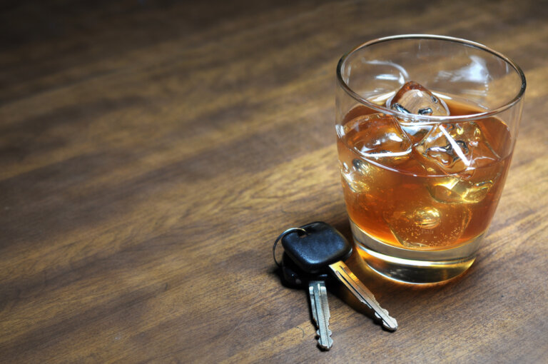 Glass of whiskey and car keys on a table