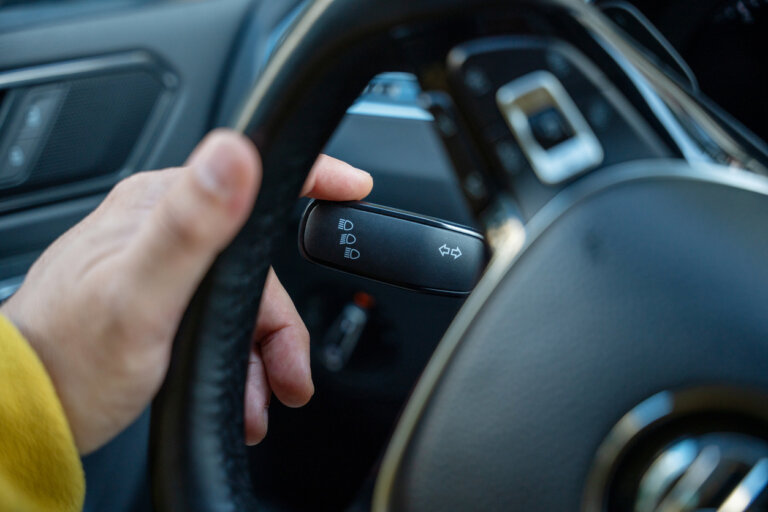 Male hand on the turn signal switch of the car