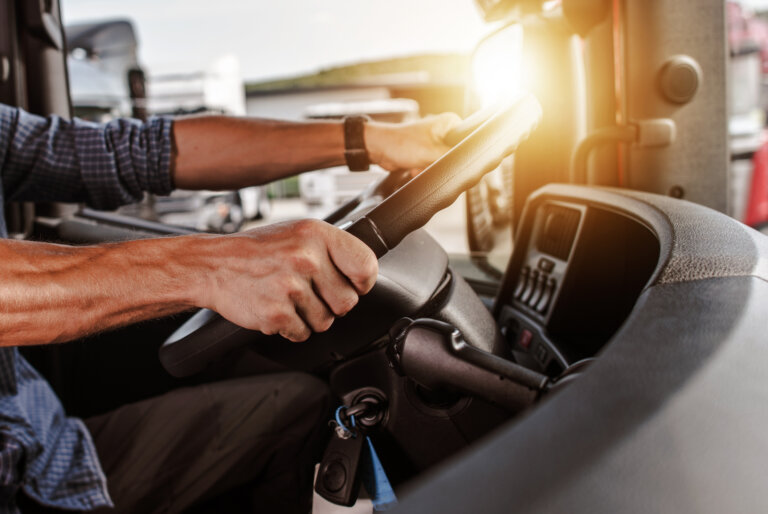Truck driver gripping the steering wheel in morning light